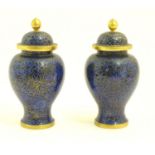 A pair of Oriental cloisonne vase and covers with a blue ground and floral and foliate detail.