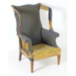 An 18thC and later wing armchair for reupholstery. 30" wide x 28" deep x 44" high. Please Note -