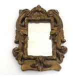 An early 20thC carved giltwood and gesso mirror with scrolling acanthus and foliate detail. Paper