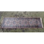 Rug / Carpet: a 20thC runner, the pink & blue central ground with floral and diamond motifs, 119"