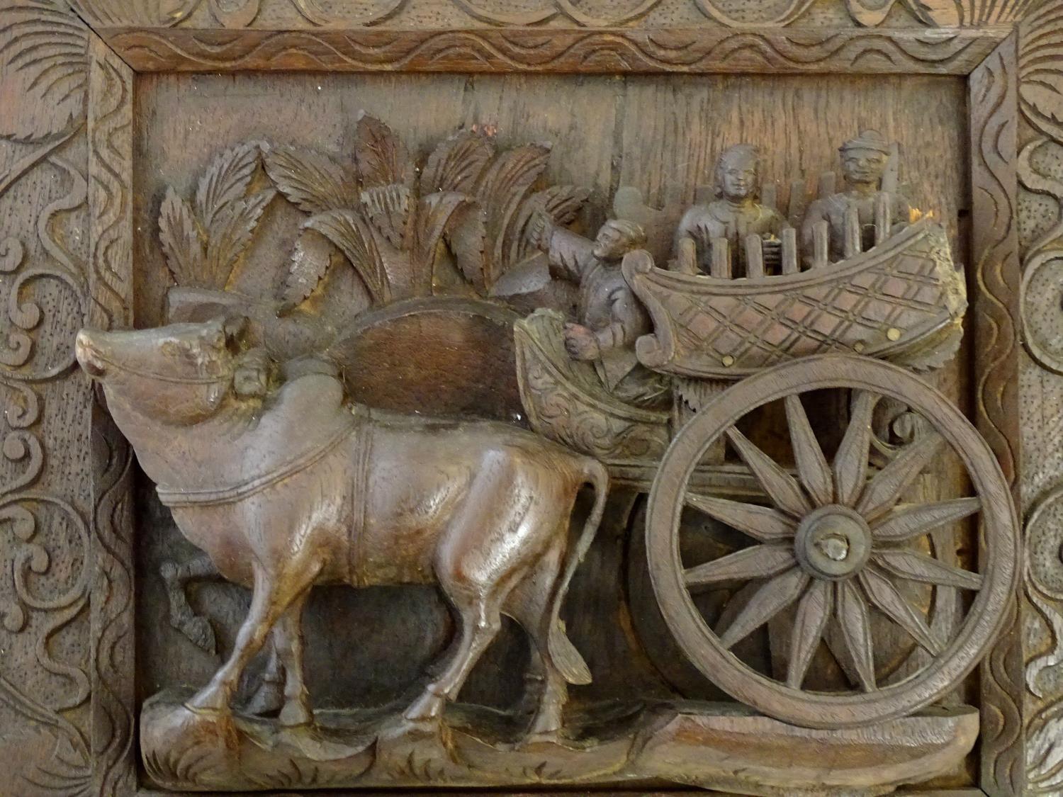 A 20thC Chinese carved wood wall plaque depicting oxon pulling a cart with figures, the border - Image 4 of 7