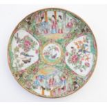 A Chinese Cantonese famille rose plate with panelled decoration depicting figures on a terrace,