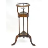 A Georgian walnut wig stand / wash stand with a rounded moulded top above three turned supports