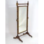 A late 19thC / early 20thC cheval mirror with decorative inlaid stringing and a rectangular
