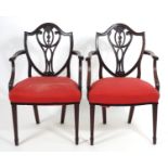 A pair of late 18thC mahogany Hepplewhite carver chairs with shield shaped backrests above pierced