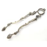 19thC Continental white metal sugar tongs, the sprung action with stylised animal detail and scallop