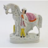 A Staffordshire pottery flat back model depicting a man and a horse. Approx. 9" high Please Note -
