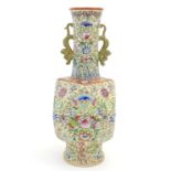 A Chinese famille jaune vase with twin handles modelled as stylised dragons, the body decorated with