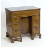 An early 20thC walnut desk with a quarter veneered and crossbanded top above one long drawer and six
