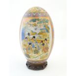 A large Japanese Satsuma temple egg decorated with Geisha girls and figures playing on a terrace