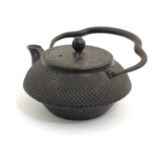 A Japanese cast iron teapot with a swing handle. Character marks below spout. Approx. 2 3/4" high