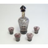 An amethyst glass liquor set comprising decanter and four shot glasses, with silver coloured overlay