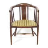 An early 20thC bow back open armchair with slatted supports above an upholstered seat and standing