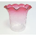 A glass shade with flared cranberry rim approx 8 1/2" high Please Note - we do not make reference to
