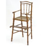 A 19thC high chair with a faux bamboo style frame and caned seat, having bowed top rails and