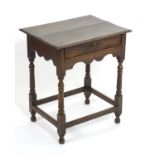 A late 17thC / early 18thC oak side table with an overhanging top above a single drawer and shaped
