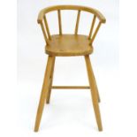 An early 20thC beech and elm childs chair with a bowed backrest and shaped seat above four turned