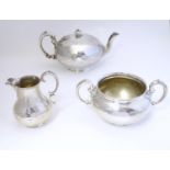A Victorian three piece silver tea set, comprising a teapot, milk jug, and twin handled sugar