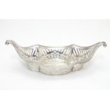 A silver boat shaped dish with scroll ends and pierced decoration. Bears a small yacht style mark