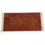 Carpet / Rug : A red ground rug with four central medallions with geometric detail and border.