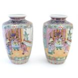 A pair of Oriental vases with panelled decoration depicting an interior scene with an Imperial