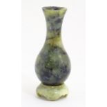 An Oriental dark mottled green carved soapstone vase on a carved base. Approx. 4 3/4" high overall