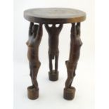 Ethnographic / Native / Tribal: A three legged African stool with figural formed legs. Approx. 20"