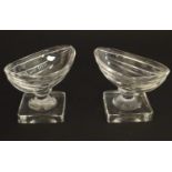 A pair of 19thC glass table salts of boat shape on squared bases. 3 1/2" wide x 2 1/2" high Please