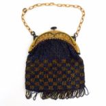 An early 20thC bead work bag / purse with checkered detail, the mount with polychrome decoration.