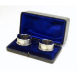 A pair of silver napkin rings with engine turned decoration. Hallmarked Birmingham 1989/1990 maker