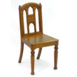 A mid / late 19thC Gothic revival hall chair with a shaped top rail, carved finials and having a
