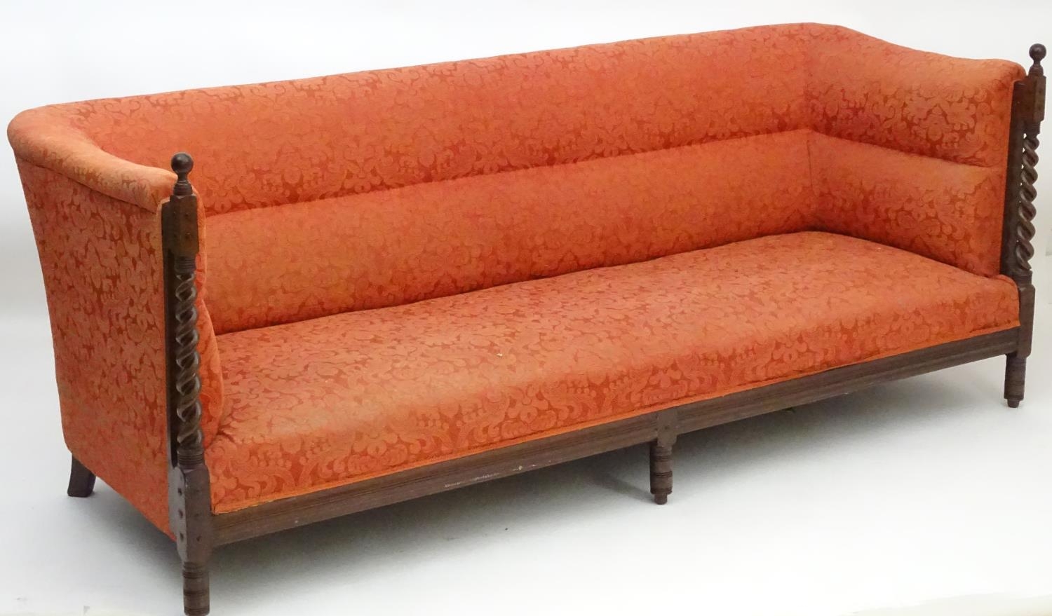 A late 19thC Arts & Crafts three seat sofa with turned barley twist pillars to the front with turned