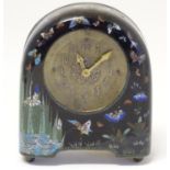 An Arts and Crafts mantle clock the case with cloisonne detail decorated with butterflies, iris,