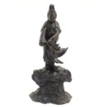 A Chinese cast sculpture modelled as the bodhisattva Guan Yin on a base of crashing waves. Approx.