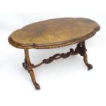 A late 19thC / early 20thC centre table with a shaped and moulded top of figured walnut