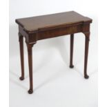 An early / mid 18thC mahogany card table with a folding top and projecting corners , standing on