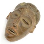 Ethnographic / Native / Tribal: A carved African mask with polychrome decoration. Approx. 9" long