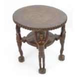 Ethnographic / Native / Tribal: An African two tier table with four figural formed legs. Approx. 20"