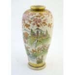 A Japanese vase decorated with a landscape scene with mountains, waterfalls, birds, pagodas, flowers