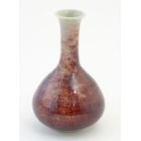 A bottle vase with a mottled sang de boeuf style glaze. Approx. 6 3/4" high Please Note - we do