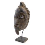 Ethnographic / Native / Tribal: A carved African mask on stand. The whole approx. 19 1/2" high