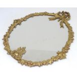 A late 20thC gilt metal mirror with a decoratively floral moulded frame. 19" high x 16" wide. Please
