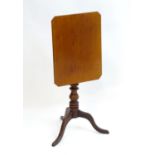 A late 18thC mahogany tripod table with a rectangular tilt top above a turned pedestal base and