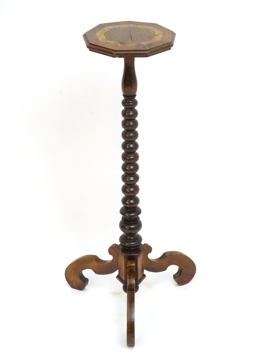 A 17thC and later walnut candle stand with a crossbanded top above a bobbin turned stem and three
