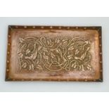 An Arts and Crafts hammered copper tray of rectangular form with repousse decoration depicting birds