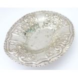 A silver plate dish of oval form with embossed decoration. Approx. 12" wide. Please Note - we do not