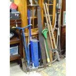 A quantity of assorted tools to include a post rammer, rag fork, pick axe, vintage saws, scythe,