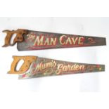 A pair of Spear and Jackson saws one with hand painted decoration ' The Man Cave ', the other with '