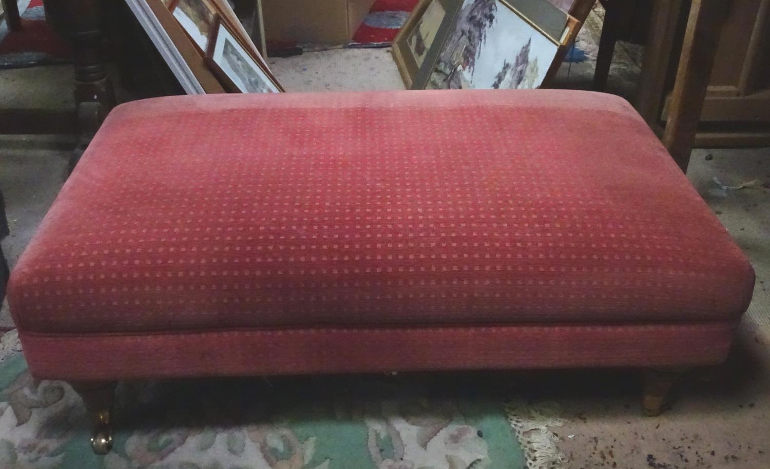 A large upholstered footstool on castors Please Note - we do not make reference to the condition