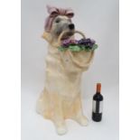 A large ceramic model of a dog with a bow and a basket of flowers Please Note - we do not make